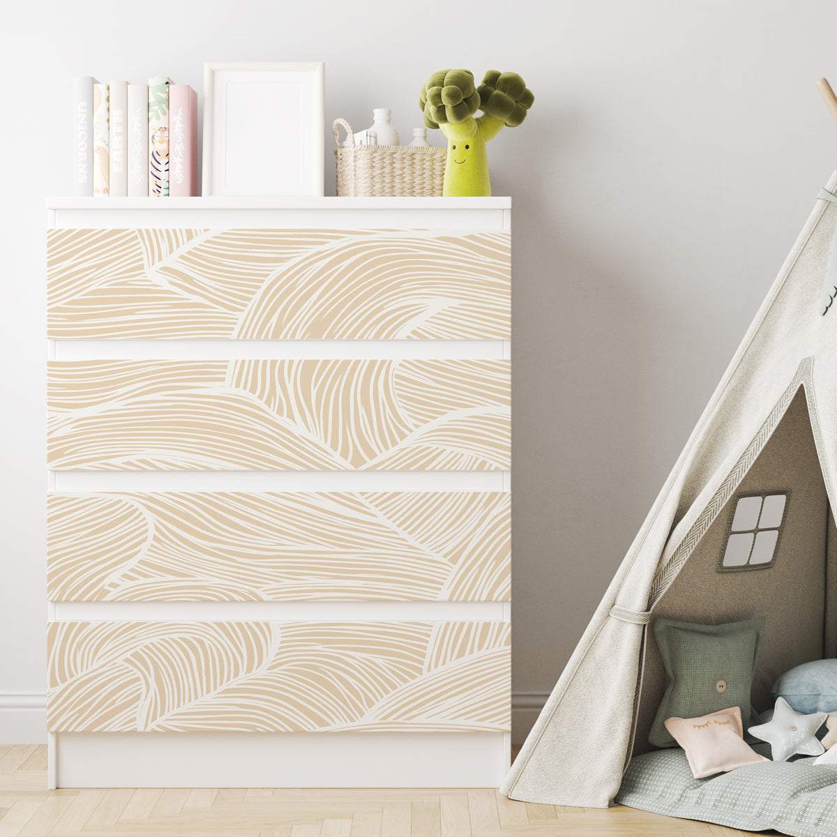 Vit IKEA MALM-byrå med fyra lådor och dekorfolie med ett abstrakt mönster av böljande beige och vita linjer.
