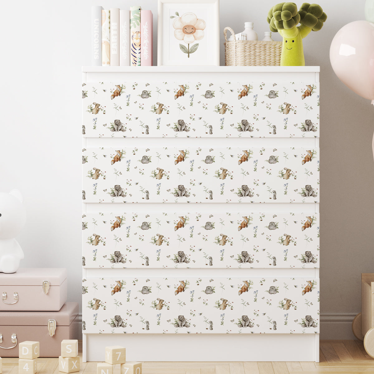 Vit IKEA MALM-byrå med fyra lådor och dekorfolie med rävar, ekorrar, igelkottar, blommor och fjärilar.
